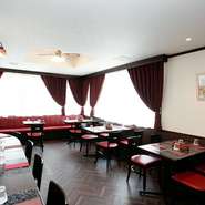 ワインレッドを基調とした店内は、昭和モダンとレトロなイメージ。どこか懐かしいながらもおしゃれな雰囲気の店内は、落ち着いて食事ができます。お店に飾られている絵画やイラストはオーナー作です。