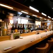 選りすぐりの地酒や焼酎がズラッと並んだカウンター。一人酒をとことん楽しめます。九州だけでなく、全国から仕入れたこだわりの地酒を飲み比べながら、美味しい一品料理に舌鼓！
