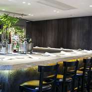 無垢材で作られた白木の一枚板の広いカウンター。素材の旨味が引き出されたフレンチと芳醇な香りと味のワインをゆったりと楽しめます。リラックスできる空間で過ごしていると時が立つのも忘れてしまいそうです。