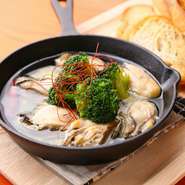 広島産の牡蠣をガーリックオイルでグツグツ煮た鉄鍋のアヒージョ。牡蠣のプリプリ感とエキスがしみ出たオリーブオイルの旨みがたまりません。そのままでもバゲットに乗せて食べても美味しいワインがすすむ逸品です。