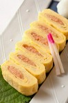 １本１００ｇ以上の太い真子を、昆布だしとかつおだしで仕込み辛子明太にし、それを玉子焼きで巻いたもの。旨みのあるピリ辛明太子のお出汁がきいているので、何もつけずに出汁の味付けだけで堪能できます。