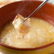 伝統的な製法の『チーズフォンデュ』。スイスのナチュラルチーズ100％を白ワインと水だけで溶かしているそう。ヨーグルト酵母を使った天然酵母のもちもちパンとの絶妙なハーモニーがやみつき。