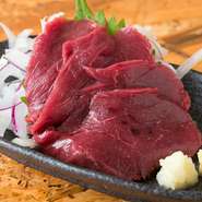 鮮度がよい馬肉を熊本から直送。すっきりしていて柔らかい食感です。馬刺しのタレは九州の甘めの醤油、薬味はニンニク。 付け合わせはムラサキ玉ねぎと大葉が定番です。