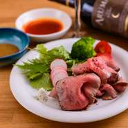 北海道産牛肉の中でも「もも肉」を厳選して使用しています。下味をつけ焼き色を付けた後はオーブンでじっくりと火入れ。杏子と柚子胡椒が香る爽やかなソースとペルー産トウガラシを使ったソースをご用意しています。