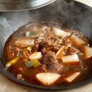 干した大根とラム肉を、鶏ガラの出汁に中国醤油や豆板醤、香辛料を加えたスープで煮込みます。うま味が染み出たスープを吸い込んだ大根と、柔らかく煮込まれたラムは、赤ワインに合う人気の一品です。