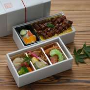 2段重の上段は煮物、焼物、揚物。下段はサラダ、デザート、うな丼になっております。大切な方への差し入れや特別な日にご利用くださいませ。（お茶付き）