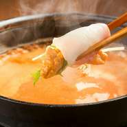 鮮魚の刺身で雲丹を巻き、それを自家製の雲丹スープにつけて食べるメニューです。刺身に雲丹の出汁がしみ込んで深い味わいになります。（二人前からのご注文となります）