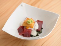自慢の『まぐろの赤身漬け』を使ったミニ丼。シャリの上に海苔、まぐろ、石川県産の丸芋のすりおろしを盛り付け、一番上にウニをのせた贅沢な一皿。おまかせコースの「しのぎ」の一例です。