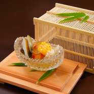 虫かごをはずすと、涼やかな器に盛られた車海老とパプリカのゼリー寄せが現れます。出汁を効かせた優しい味わいで、黄身酢の酸味がアクセントに。さらに、蒸しアワビと白キクラゲが贅沢な風味と食感を添えています。