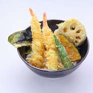 えび2尾に季節の野菜、海苔の入った天丼。サクサクの天ぷらと甘辛いタレのしみたご飯が絶妙のバランス。単品の天ぷらを追加して、カスタマイズすることもでき、100円プラスすればお味噌汁付の定食にもできます。