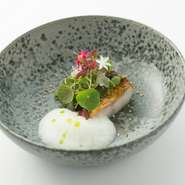 真空減圧調理を用いて甘鯛自体に旨みを逃すことなくもどし、スパイスのクレマとニラから抽出したオイルをかけた香り高い一品。