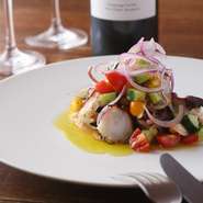 シンプルな仕上がりのカルパッチョですが、淡路タコを塩もみした後にクール・ブイヨン（野菜のくずや香草スパイスなど）で下処理をするので、野菜の風味がしみこみ皮もやわらかく召し上がっていただけます。