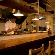 お客様との対話を大切につくられたカウンターのみの店内。木の温もり溢れる空間は、居心地が良く一人でも気軽に立ち寄れる雰囲気です。仕事帰りに美味しい料理を気軽に食べたい、そんな思いを叶えてくれるお店です。