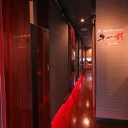 静かにたたずむ、木目を活かしたシンプルなデザインの店。窓辺に飾ったワインボトルが、大人っぽくオシャレな印象を与えます。扉の向こうには、穏やかな空気が漂う店内空間が広がっています。