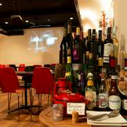 白い壁の店内に、落ち着いた赤と黒のイスを配置。ワインの樽やテーブル、棚に並べたワインボトルも、さりげなくセンスの良さを感じさせます。