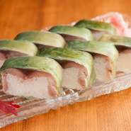 魚屋さんにいい鯖が入荷した時のみつくるという『鯖棒ずし』。赤鍋で炊き、薬品を使わずキレイな緑色に染まった白板昆布と一緒に召し上がれ。