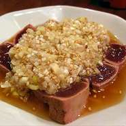 新鮮な豚レバーの炙り焼。火を通していますが、レバ刺しに近い食感が残るように調理されています。中は柔らかく、噛むとレバーの濃い旨味と特製のネギダレが口の中に広がる逸品です。