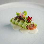キャビアの塩味や旨みをベストバランスで受け止める組み合わせとして試作を重ね行き着いたのが、本マグロのタルタルをアボカドのスライスで巻いたカネロニです。下に敷いたリンゴが酸味と甘味をプラス。
