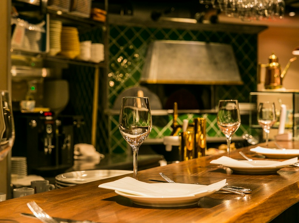 職人がピッツァを焼く様子を見ながら、カウンター席でデートを