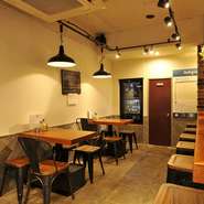 暖色系を基調とした店内は、肩肘張らずにくつろげる空間。余計な装飾を省いたシンプルなインテリアが、カジュアルな雰囲気を演出しています。オープンキッチンから伝わる調理の音も心地よく響きます。
