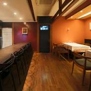 梁が印象的な店内は、カウンター席の壁はヨーロッパ風の紅、テーブル席の壁は日本の伝統的な朱色に仕上げ、和洋折衷の妙を演出。器も、フランス製の皿、有田焼や美濃焼などを用い、和洋の彩りを添えています。