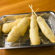 【だしまる】を訪れたなら絶対食べて欲しいのは、『ふわふわ串かつ』です！生地を独自に発酵させたものを使用しているので、独特なふわっとした食感が楽しめる串揚げです。