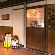 店前にあるぽんぽこたぬきと、提灯が目印！明かりがついたら営業開始です！店内が見やすいように入口の扉は、ガラス窓を付けました。気軽にどうぞいらっしゃい！