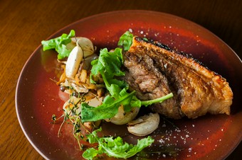 カリッカリに焼き上げた沖縄産アグー豚皮つきバラ肉のコンフィ、スパイスの香り