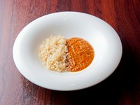 国産の牛バラ肉をトマトと玉ねぎ、赤ワインでじっくりと数日間煮込んで食感に仕上げました。肉の旨みが溶け込み、仕上げに生クリームをプラスしてコクを加えました。硬めに炊いたバターライスとの相性は抜群です。