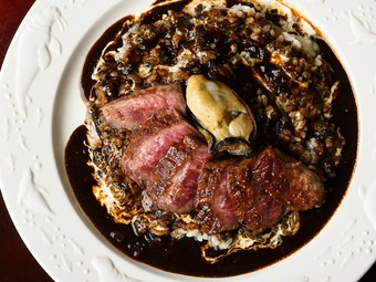 スパイスの効いた真っ黒『ステーキのせカレー』は、ランチタイムの人気メニュー