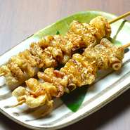 通常の１，５倍程度のジャンボ鶏皮串に秘伝のタレとスパイスで仕上げた特製鶏皮串。手羽先とは一味違った味わいです。