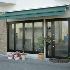 シンプルで爽やかな外観、モスグリーンのオーニングが印象的