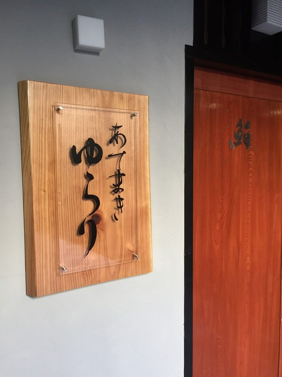 ビルの脇の通路を抜けると木製の扉と看板が目を引く