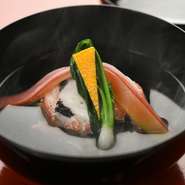 昆布と鰹の旨味を、京都の水でたっぷりと引き出した月替わりのお椀。写真は、蟹と魚のすり身をやわらかく蒸した「しんじょう」と、紅白の大根や末広の柚子、うぐいす菜で祝事向けに。