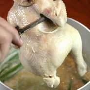 お店自慢の鶏を丸々一羽使用した豪快な鍋。濃厚な白湯スープで長時間煮込んだ鶏は、ジューシーでありながら一口食べると、お肉がホロホロととろけます。〆はラーメンか雑炊で！