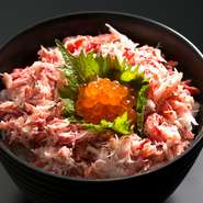 しっとりジューシーな本ズワイガニを贅沢に使用した『カニ丼』。本ズワイガニの出汁で炊き上げたご飯の上に、たっぷりのカニのほぐし身とイクラ、カニみそが添えられているカニ専門店【かじま】の自慢の一品です。