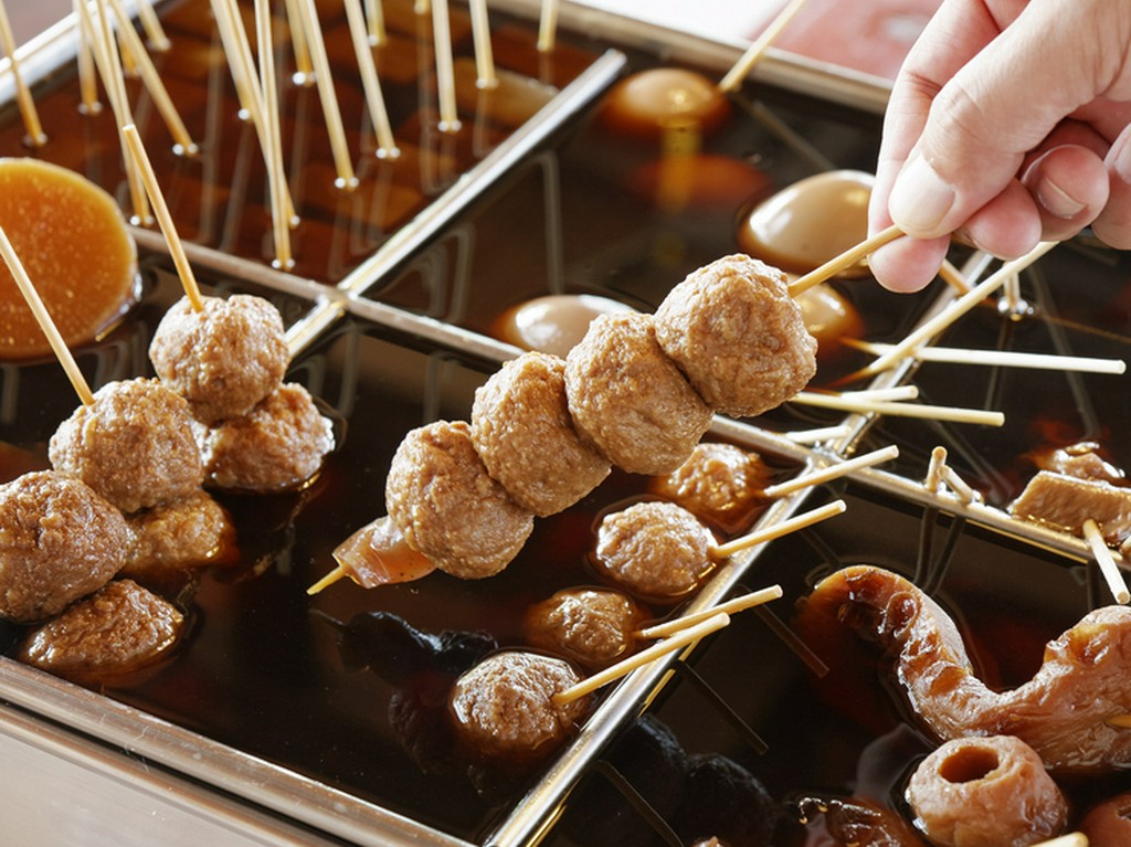 どっしりとした安定感のある丸太に座り、讃岐うどんを楽しむ