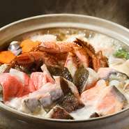 『宴会鍋Ｃコース』で供される鍋には、金目鯛、さわら、アイナメ、タラ、鮭、白子、牡蠣、それに毛ガニなど魚介がたっぷりと入っていてともて贅沢。海鮮の味を引き出すために、薄めの醤油出汁をベースにしています。