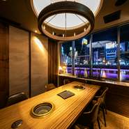 那珂川に沿った窓辺の席は、窓が大きく縁どられ、川向こうの中洲の街が一望できます。お店は17時からの営業なので、窓辺の席なら、中洲のネオンと、それらの光を反射する川面が、一層雰囲気を盛り上げてくれます。