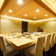 存在感のあるL字型のカウンターは吉野檜の一枚板。栃木県の大谷石を使った壁が、柔らかい雰囲気を演出しています。洗練された佇まいは、記念日のデートや夫婦でのお食事などにぴったり。