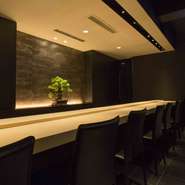 ビルの外階段を上がって一番奥にある【中目黒いぐち 本店】。知らないと気付かない店構えは、隠れ家的な雰囲気が魅力です。扉を開けると、シンボルの五葉松と一枚板のカウンターが目を惹きます。