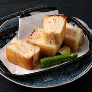 海老と玉ねぎ、大和芋をつかい、素材の味わいが引き立つよう薄味に仕上げた海老しんじょ。薄めの食パンに挟み揚げているので、ふんわり海老とサクッとしたパンの食感が絶妙です。お酒との相性も抜群！　