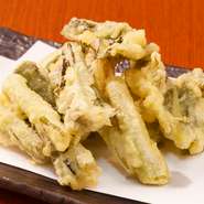 昔から受け継がれている伝統の食べ方で、野沢菜の漬物を揚げた天ぷら。シャキっとカラッとした食感で、酒のつまみにも最適。
