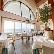 南イタリアの清潔で温かい雰囲気を演出する店内からは、七里ヶ浜の海を一望できます。天気が良ければ、江の島や伊豆の大島、三浦海岸まで見渡せる絶好のロケーション。記憶に残る時間になりそうです。