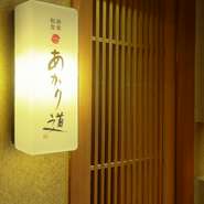 熊本の歓楽街の中心通りから一本中に入った場所で、ひっそりと看板を掲げる【あかり道】。街中の喧噪を忘れ、ゆったりとした時間が過ごせる和食店です。控えめな佇まいが上質な大人の空間へと誘います。
　