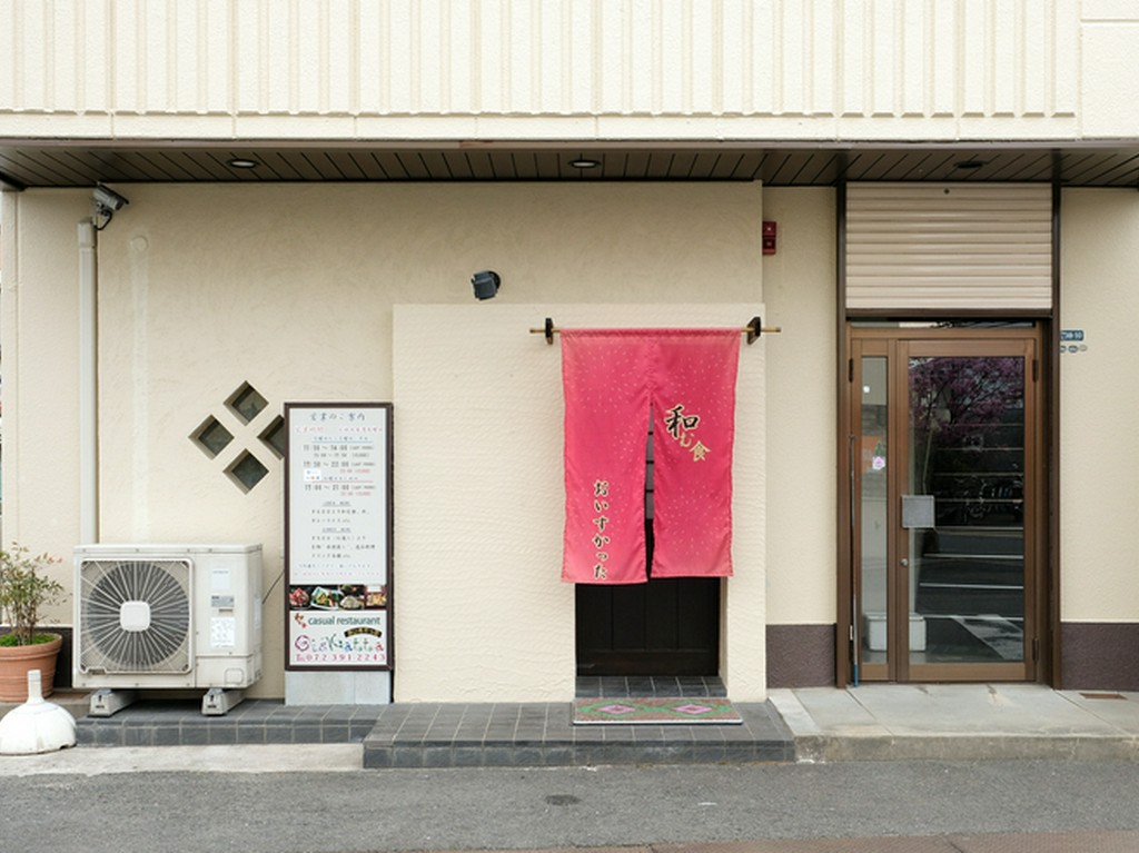 白い壁に映える赤いのれんが目印