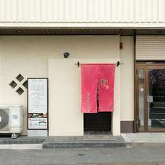 白い壁に映える赤いのれんが目印