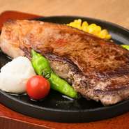 特選牛のサーロインステーキを、グラム指定で焼いてもらえるメニューです。塊肉を切って鉄板で焼いたジューシーなステーキは、ニンニクチップと生野菜でいただきます。200gからオーダーできます。