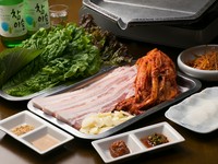 韓国の焼肉料理の一種で、豚バラ肉をキムチやニンニクといっしょに焼いて、野菜に包んで食べるものです。【焼肉モランボン】では、店長が焼いてお客様に提供。豚肉は、特注の皮付き豚バラ肉を使っています。