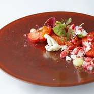 前菜の一例。上品な旨みが特徴の岩手産サーモンをコンフィにし、いちごの甘酸っぱさとビーツの甘苦さを生かしながら、サラダ仕立てに。鮮烈な色彩と新鮮味のある味わいを楽しめます。盛り付けの美しさも絶妙。